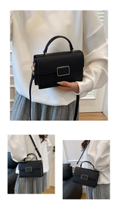Detailed view of black litchi pattern leather bag with golden buckle and crossbody strap