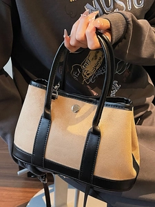 Chic two-tone bucket bag in beige suede and black leather with a round metal clasp