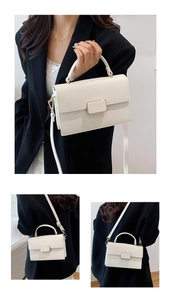 Detail of white lychee leather texture with gold metal buckle on elegant square bag