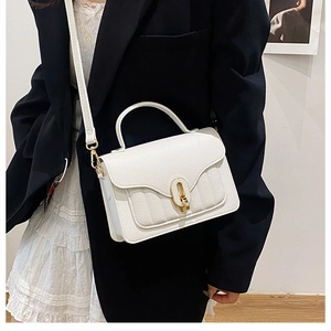 Detail of white lychee pattern leather handbag featuring elegant gold oval twist lock