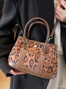 Chic leopard print bucket bag with brown leather trim and detachable shoulder strap