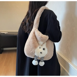Detail view of pink plush bucket bag featuring a 3D rabbit doll and soft faux fur texture