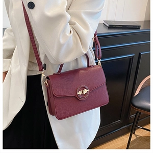 Détail du sac à main en cuir bordeaux avec fermoir anneau doré et bandoulière