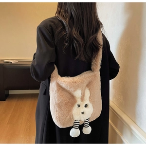 Detail of plush bucket bag in camel brown with 3D bunny design on back of black coat