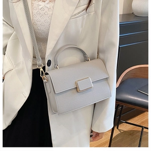Detail of grey lychee pattern leather square bag with matching buckle and gold hardware