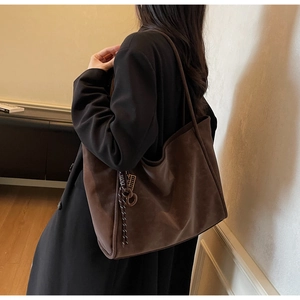 Detailed macro view of high-quality brown suede texture and decorative knot on tote bag