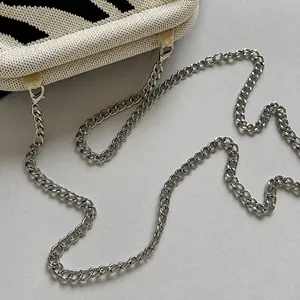 Detail showing the silver metal chain strap attached to the zebra knit shoulder bag