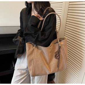 Close-up of beige vintage tote bag with elegant texture and decorative ribbon accessory