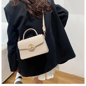Détail du mini sac à bandoulière beige en cuir texturé avec fermoir en métal doré
