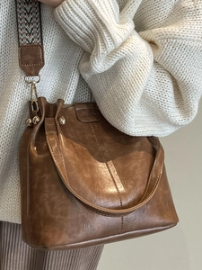 Vintage brown PU leather bucket bag with wide woven strap and gold hardware accents