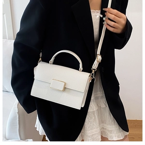 Detail of white leather mini square bag with golden buckle and sleek hand strap