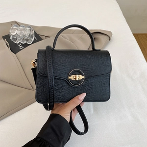 Détail d'un sac à main en cuir grainé noir avec fermoir rotatif doré élégant