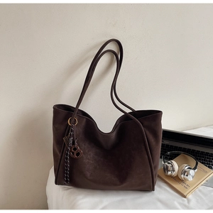 Close-up of the dark brown faux leather tote bag with accessories and decor