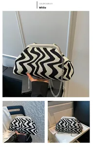 Detail of black and white wavy knit pattern bag with silver metal chain strap