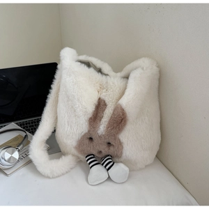 Detail view of white plush bucket bag with cute brown rabbit design on home desk