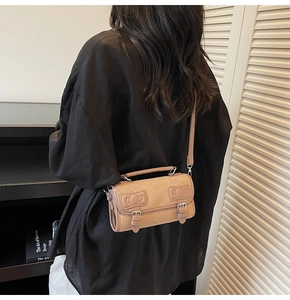 Detail of minimalist beige Boston bag with leather straps on a person for daily styling