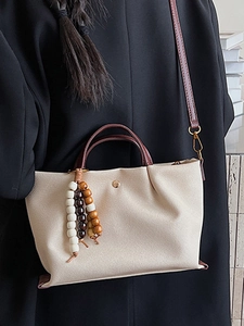 Minimalist beige canvas crossbody bag with pleated sides and brown leather straps