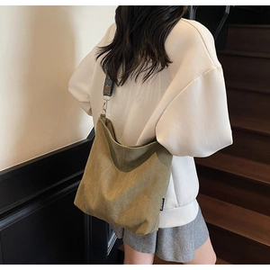 Detail of olive green canvas tote bag with retro ethnic pattern wide strap and metal buckle