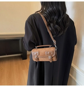 Brown suede pillow bag with bow detail worn by model showing crossbody style fit