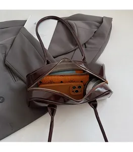 Interior view showing large capacity of the brown Boston bag with phone and wallet