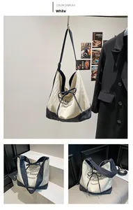 Detail of canvas tote bag with blue denim stitching and decorative ribbon bow