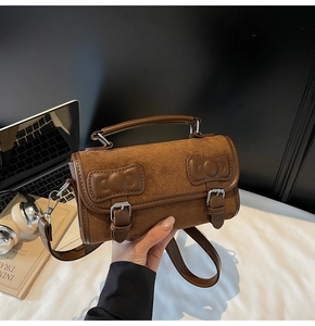 Close-up of brown leather patchwork bag with bow details and stylish metal buckles