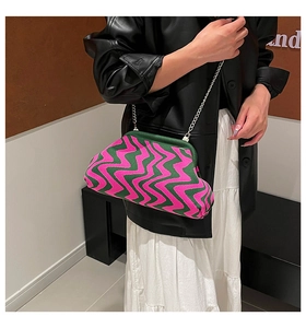 Close-up of pink and green zigzag knit shell bag with silver chain strap and metal clasp