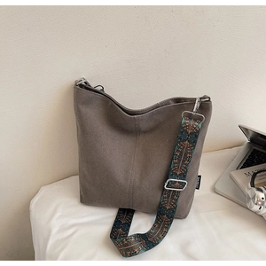 Detail of adjustable wide canvas strap with ethnic geometric embroidery and metal hardware