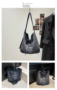 Detailed close-up of leopard print and denim canvas tote bag with drawstring closure
