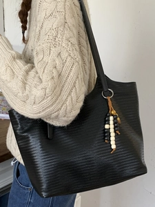 Grand sac cabas vintage noir tissé avec pendentif perlé porté comme un sac à bandoulière