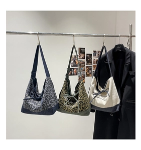 Detailed display of large canvas tote bags in leopard prints and neutral patchwork styles