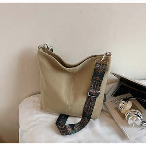 Macro view of khaki canvas tote with colorful geometric patterned wide shoulder strap