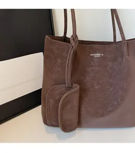 Detail of brown vintage leather tote bag showing textured finish and matching pendant