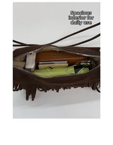 Detail view of the spacious inner compartment of the brown fringe crossbody bag
