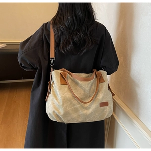 Rear view of a model carrying the large vintage canvas tote bag with contrast straps