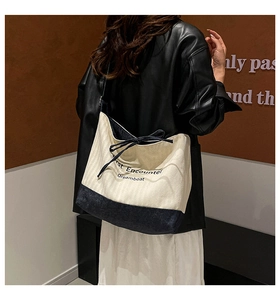 Close-up of contrast canvas tote bag with artistic typography and ribbon bow detail