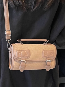 Minimalist camel suede Boston bag with leather trim and decorative bow accents