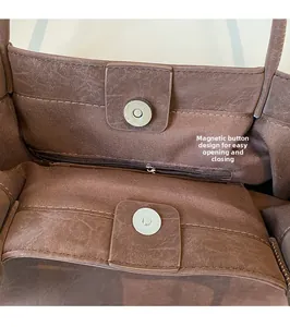 Detail view of the secure magnetic closure and internal zipper pocket on brown tote bag