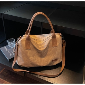 Detail of vintage khaki canvas tote bag featuring retro texture and adjustable shoulder strap