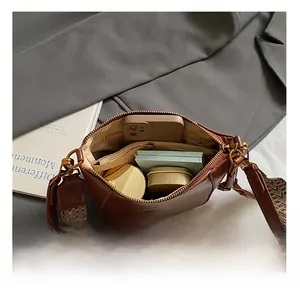 Internal view of brown leather crossbody bag showing large capacity and zipper pocket