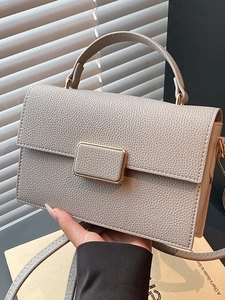 Minimalist beige pebble leather square handbag with golden metal buckle and top handle