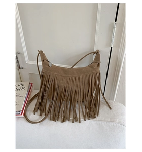 Detail of a brown suede shoulder bag featuring a stylish long tassel and matte finish