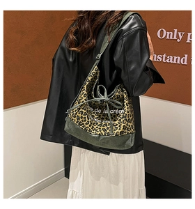 Detail of leopard print canvas tote bag with drawstring bow and green wide strap
