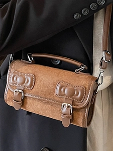 Vintage brown suede pillow bag with dual bow accents and silver buckles in 45-degree view