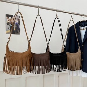 Detail of four fringe suede half-moon bags in caramel, dark coffee, black and khaki