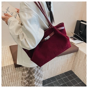 Close-up of wine red velvet tote bag with elegant silver metal buckle detail