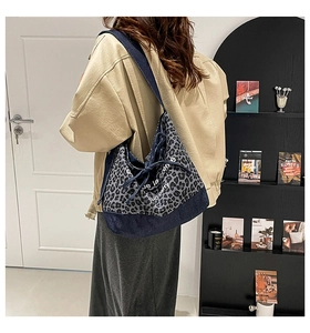 Detail of leopard print canvas and denim patchwork tote bag with drawstring closure