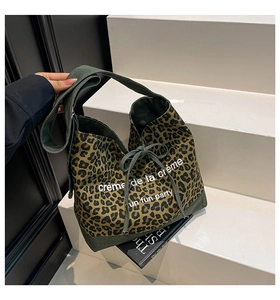 Detail of leopard print canvas tote bag with drawstring closure and printed lettering