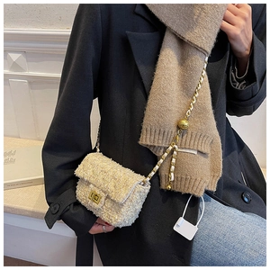 Detail of tweed crossbody bag featuring gold chain strap with ball charm adjustment