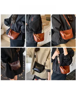 Detailed view of women's vintage shiny leather saddle bag with tassel and wide strap